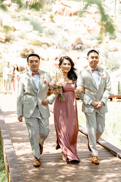 Bridesmaid and two groomsmen walking down the aisle to the tunes of harp wedding songs at Red Rock Boardwalk, Red Rock Canyon, Las Vegas.