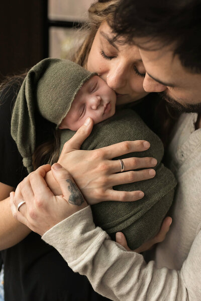NJ  Family Photographer catches parents kissing small baby