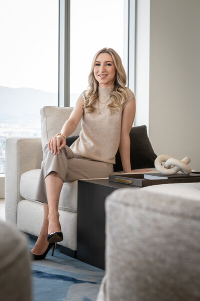 Georgia Longo, lead designer. She is a white woman with curled blond hair, she's wearing a beige top and capris, and smiling