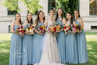 Bride and bridesmaids standing together with bouquets