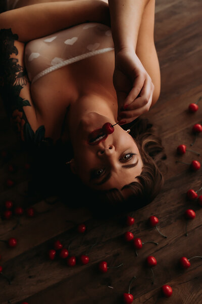 boudoir shoot woman biting cherry