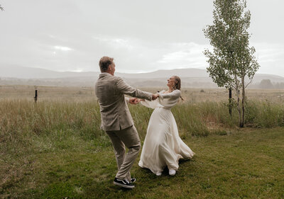A couple dancing in the rain during their elopement in Aspen, Colorado.