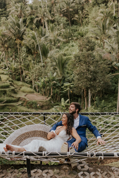 bride and groom sitting on large hammock