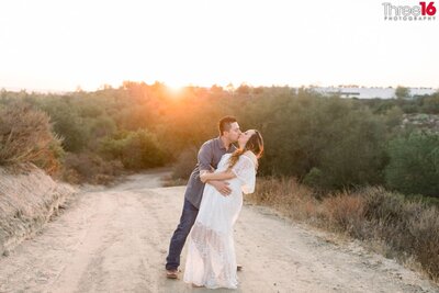 Engaged couple hold each other and look into each other's eyes during their Whiting Ranch Wilderness Park engagement session in Trabuco Canyon