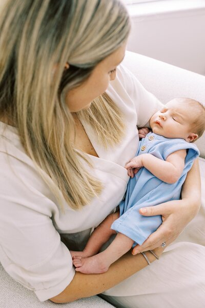 mom holding newborn baby in rocker