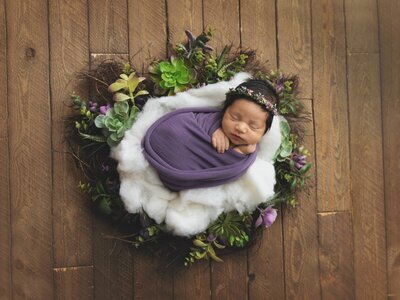 Newborn baby girl with flower crown on wreath