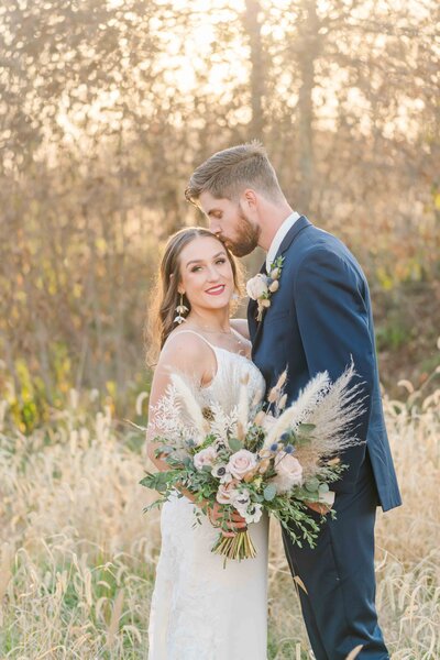 newlyweds hugging with bright floral bouquet