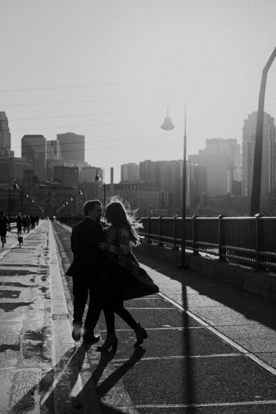 a couple embracing with the city behind them
