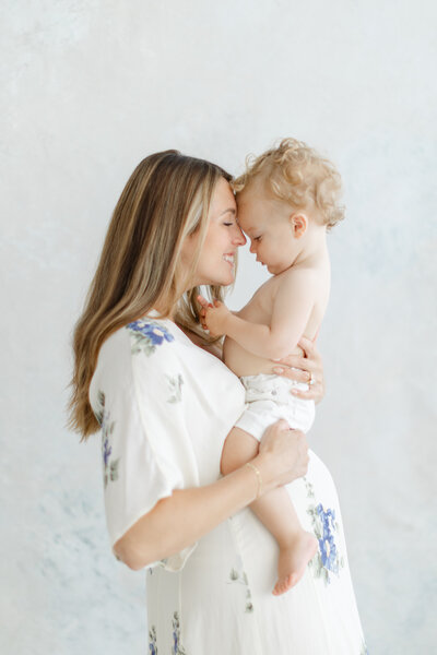 Pregnant woman holds her older child on her belly