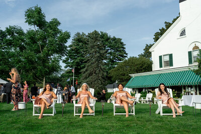 Part of bridal party sitting in adirondack chairs, wedding was at Connemara House