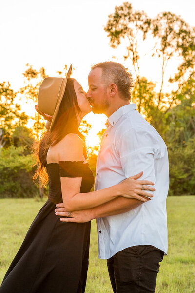 woman in black sharing a kiss with husband at sunset - Townsville Couples and Engagement Photography by Jamie Simmons