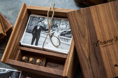 A wooden keepsake box with black and white images tied with a string.