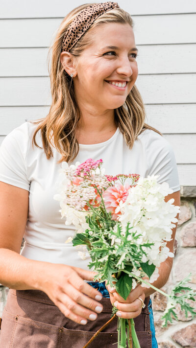 Woman holding a bouquet of flowers looking off camera and smiling