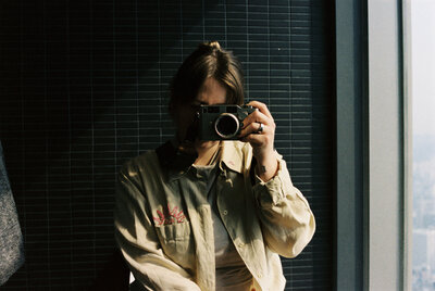 woman taking self portrait in mirror in seoul