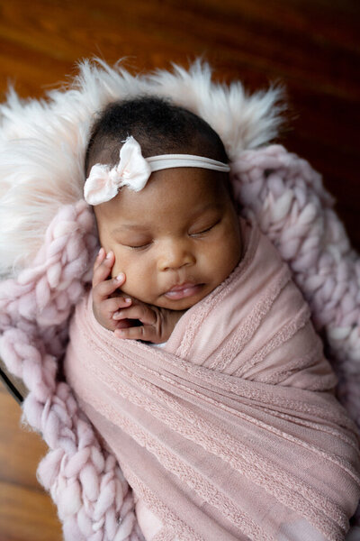 Newborn session of baby girl in purple swaddle