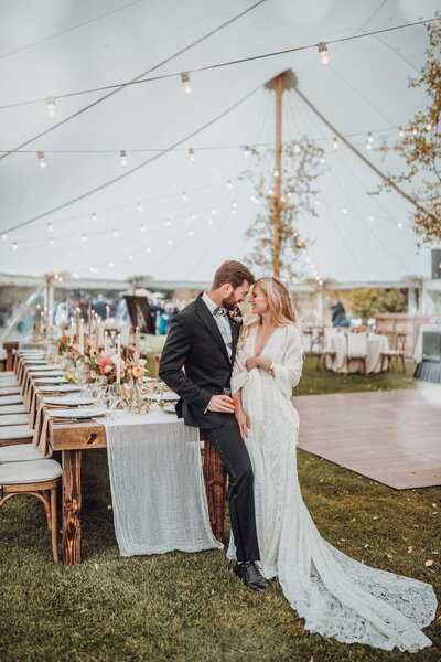 bride & groom stand together in their rustic elegant wedding reception tent in Jackson Hole