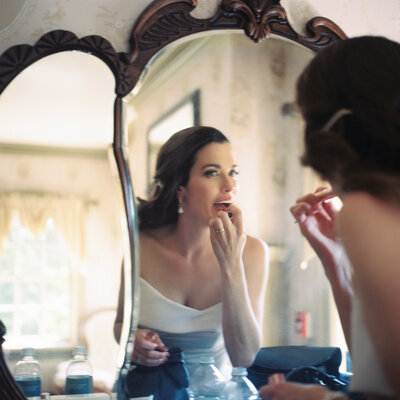 a bride puts on lipstick in the Felt Mansion mirror - photographed on film from the Yashica Mat 124g