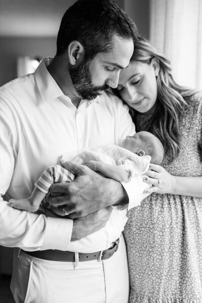 Father and mother hold baby girl in newborn photo by Indianapolis photographer Katelyn Ng