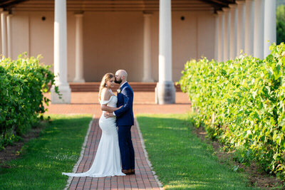 bride and groom in front of pillars  by wedding photographers in georgia