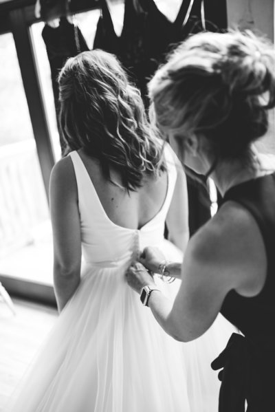 Bride's mother helps her into gown at Greengates Farmhouse, Laurel, MS, Mississippi Wedding