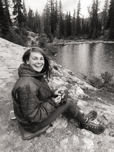 black and white image Natalie sitting by lake