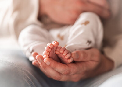 dad holds babies feet in hands