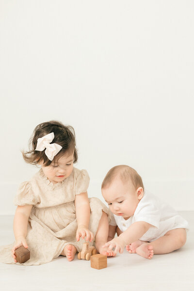 A young brother and sister playing on the floor with blocks by NJ Newborn Photographer