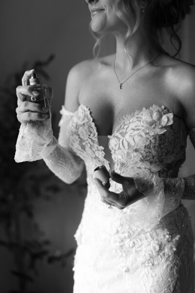 Photo of bride putting on perfume