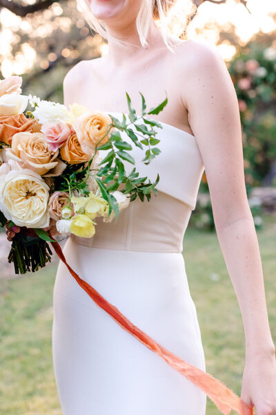 Bride plays with bouquet ribbons