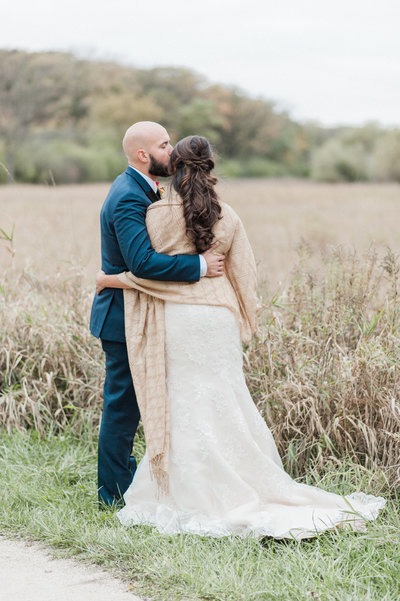 couple hugging in rustic wheat field