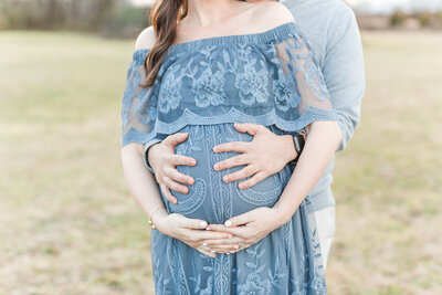 A closeup photo of a pregnant mother's belly being held by mom and dad by Northern Virginia Maternity Photographer Northern Virginia Maternity Photographer