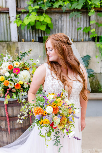 bridal portraits with red-headed bride with braid and long hair and colorful bouquet