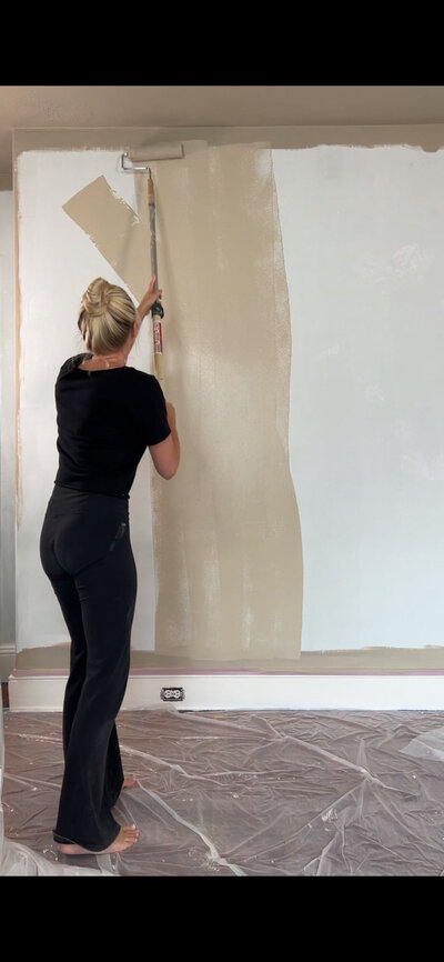 Haley painting a white wall a warm neutral color
