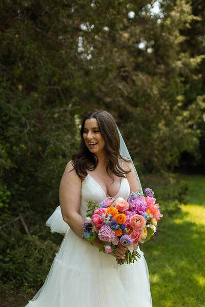 bride with her bright colorful bridal bouquet at her spring wedding