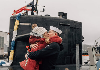 Petty officer third class embraces partner at  USS Newport News Homecoming in Groton, CT.