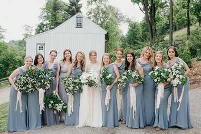 Bridal party pose at this family farm wedding, holding unique dogwood branch bouquets by Wild Stems.