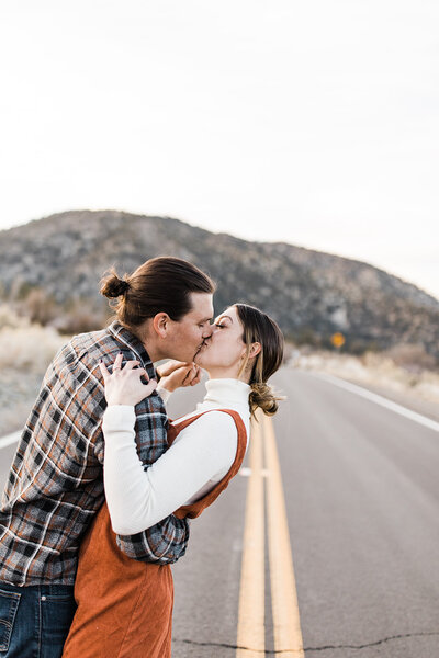 couple kissing in the street with mountains in the background in los angeles