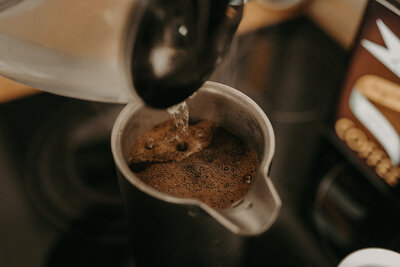 Kaffee wird mit heißem Wasser in einer Thermoskanne aufgegossen.