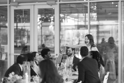 Candid laughs shared at Downtown Market reception – West Michigan wedding photographer