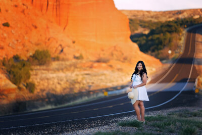 Senior girl standing next to the rd at Lake Mackenzie in a white dress