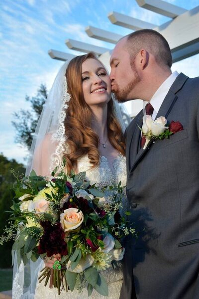 redhead bride in a traditional  gown with a classic bridal makeup look and pink lips in San Jose CA