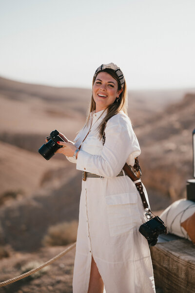 Sarah Hurja holding camera smiling in the Agafay desert.