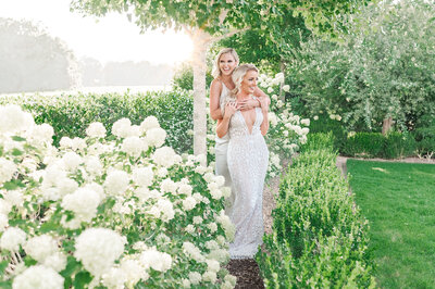 Two happy brides laughing in a Raleigh garden at sunset by Raleigh wedding photographer, JoLynn Photography