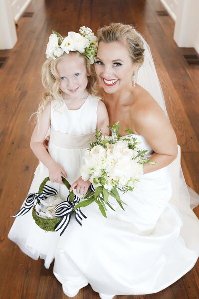 Bride posing with her flower girl on wedding day