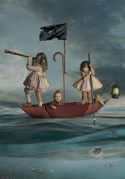 creative concept portrait of children in umbrella floating over open sea