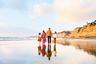 Family hugging on the beach at sunset by Loni Brooke Photography, a San Diego Portrait Photographer