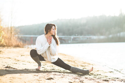 Woman in a yoga pose on the beach