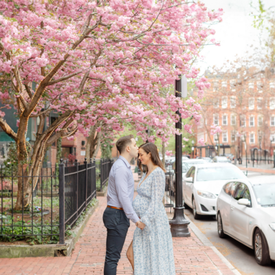 expecting mother wears floral dress in downtown boston during maternity photoshoot