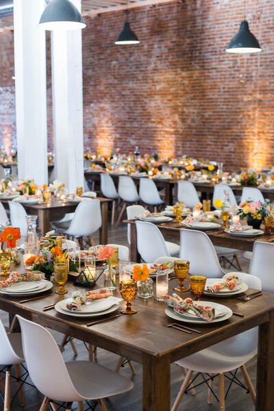 Wedding reception space decorated with tables and place settings