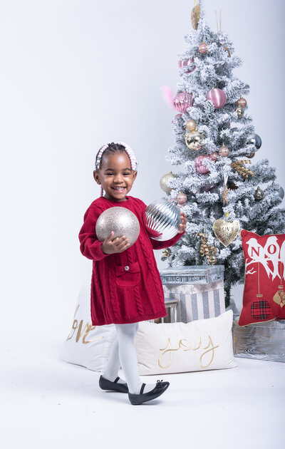 Happy toddler with christmas  ornaments photo session